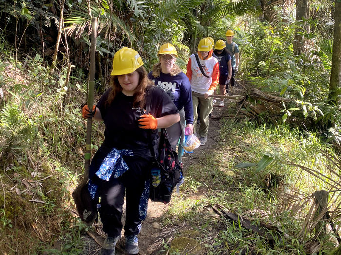 Students make their way along a trail, on their way to perform trail maintenance in the El Yunque National Rain Forest during the alternative spring break trip in Puerto Rico.