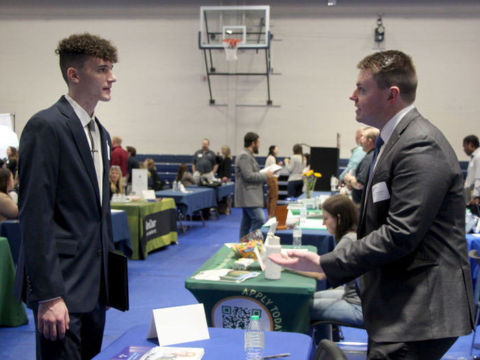 Penn State DuBois student Tristan Parker, left, talks with alumni Caleb Bennett, financial professional with Equitable Advisors, during the career fair at the PAW Center.