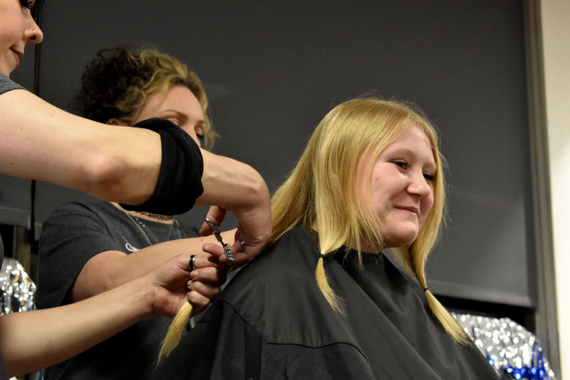 Abby Freemer has her hair cut after donations reach her goal during the THON hair auction