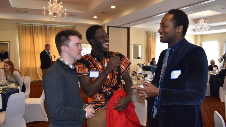 Carlos Jeremie, at right, talks with fellow scholarship recipients Stanley Igbudu, center, and Jacob Butterfuss, left.