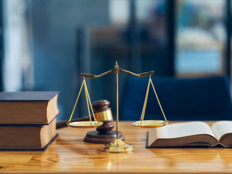 Symbols from the criminal justice system; a scale, a gavel and legal textbooks