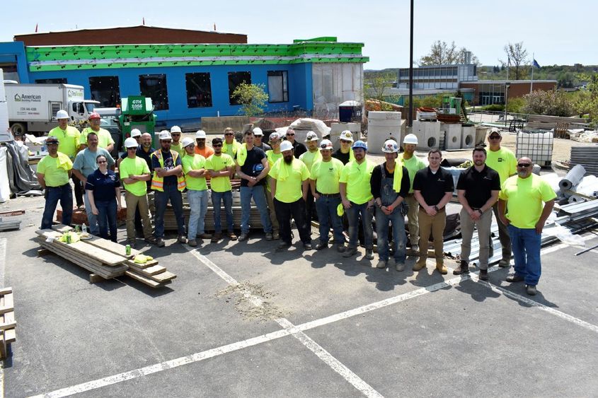 Construction team poses in front of PAW Center building during construction