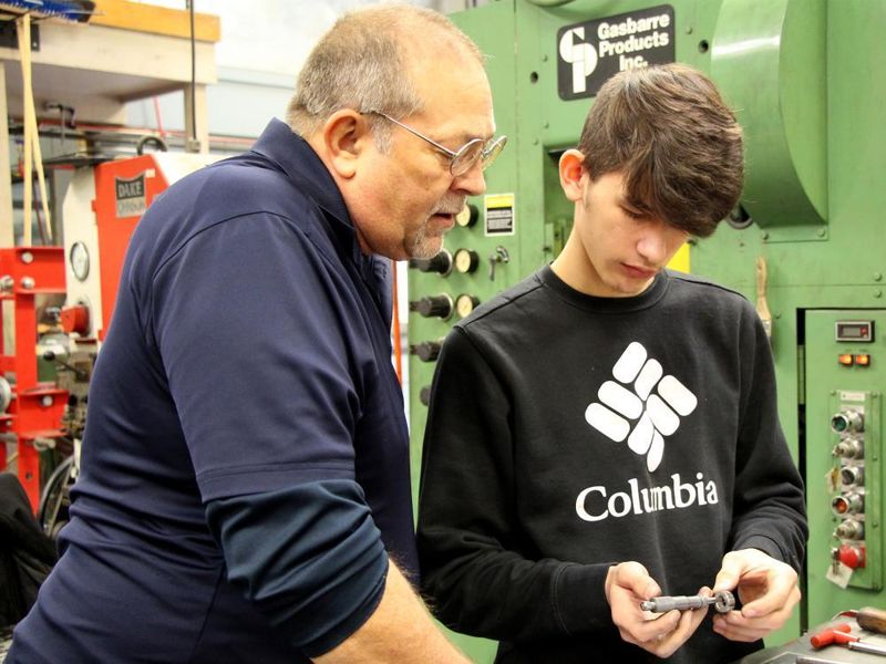 Penn State DuBois die setting instructor George Schneider, left, works with Saint Marys Area High School student Dakota Larkham to measure one of the parts produced during the high school die setter training program.