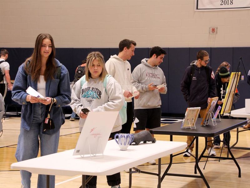 Attendees view some of the artwork submitted at the annual campus and community art show, hosted by the IDREAM Team at Penn State DuBois.