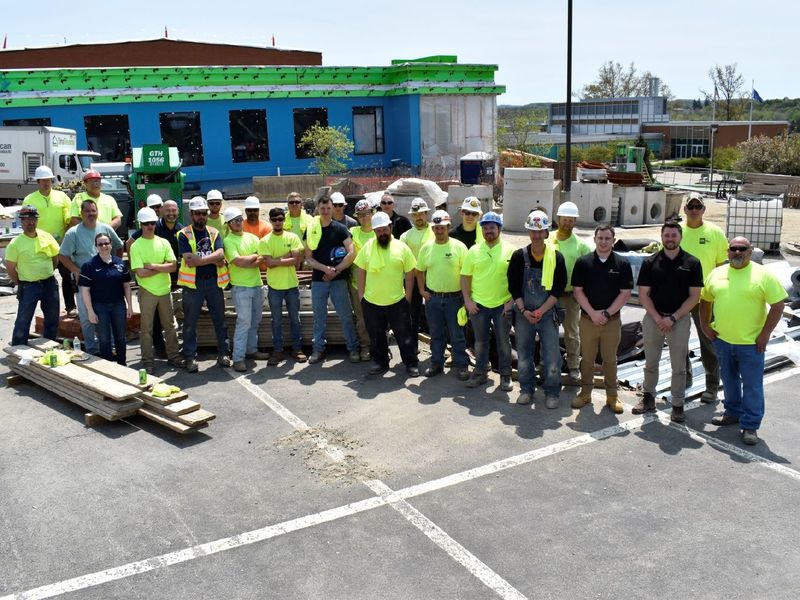 Construction team poses in front of PAW Center building during construction