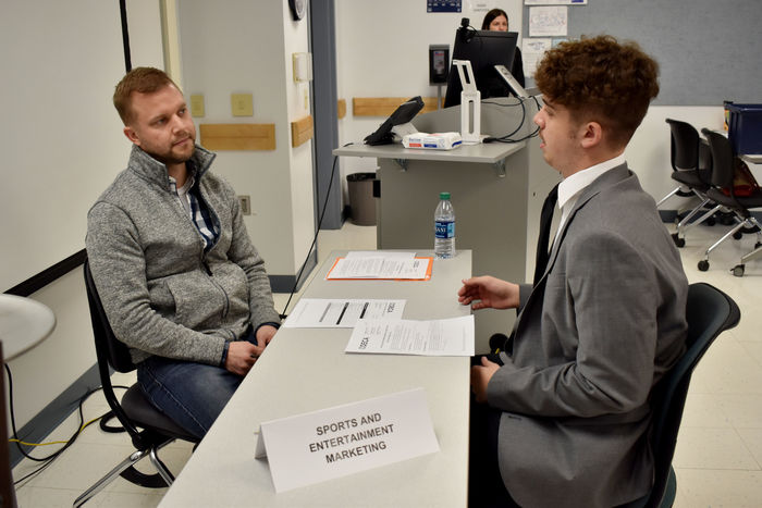 A student gives his role play scenario presentation to a judge during the 2022 Pennsylvania DECA district one conference.