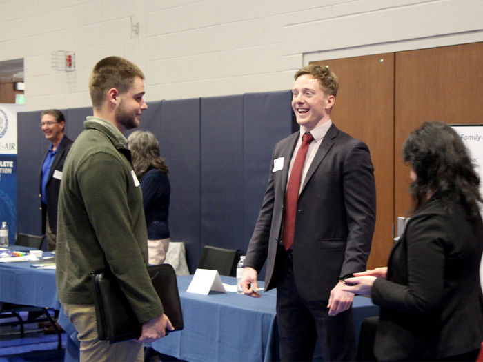 Penn State DuBois senior Dylan Treaster, left, talks with Zane Morgan, right, of CNB Bank and Penn State DuBois alumnus, during the career fair at the PAW Center