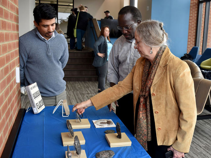Jeanne Stevens-Sollman shares details of her metal workings with Amila Madiligama, assistant teaching professor in physics, left, and Daudi Waryoba, associate professor in engineering, during the “Let’s Represent Art Show”, held in February at Penn State DuBois