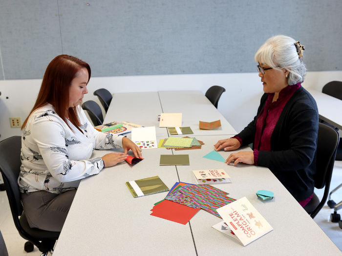 Hyeseon Kim, community outreach coordinator for the institute for Korean studies, right, guides Marly Doty, lecturer in human development and family studies, through an origami activity during the DEIB workshop held at Penn State DuBois in October.