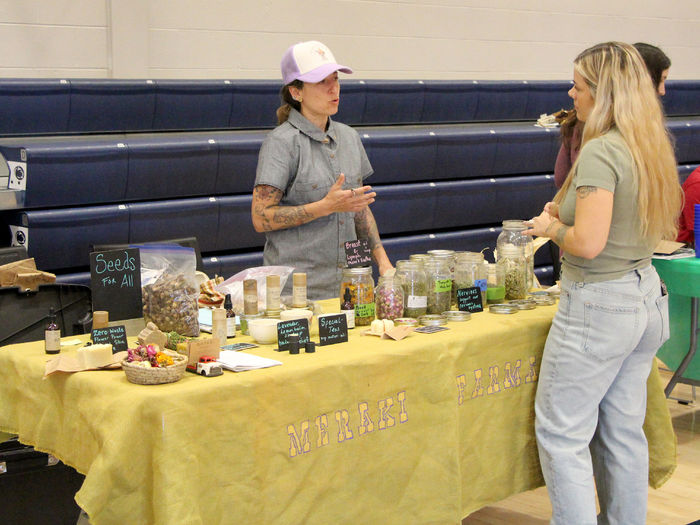 A representative from Meraki Farmacy discusses their products to an attendee during the Earth Day Celebration at Penn State DuBois.