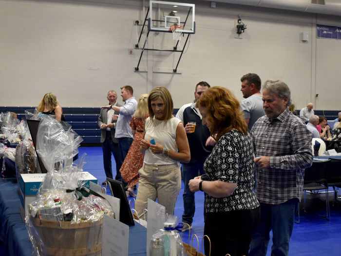 Attendees of the Lion Wine and Cheese fundraiser look over the items available in the basket raffle during the event at the PAW Center