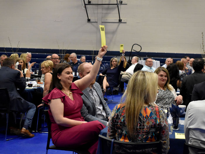 A bidding battle breaks out for one of the items up for auction during the Lion Wine and Cheese live auction at the PAW Center