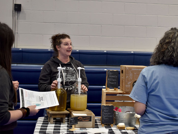 Representatives from Calhoun Farms explaining their sustainability efforts through ecofriendly refillable products to attendees of the Earth Day celebration at Penn State DuBois