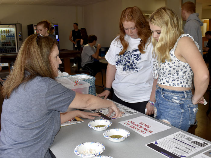 Penn State DuBois students Chelsea Busatto, left, and Makena Baney take part in an interactive learning exercise about fentanyl, with guidance from Jill Betton, health services coordinator and campus nurse, during the Weed It Out event on campus