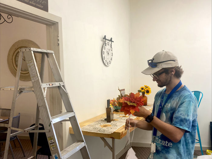 Penn State DuBois student Austin Dinsmore hangs fall decor at the Soul Platter Café during the recent day of service.