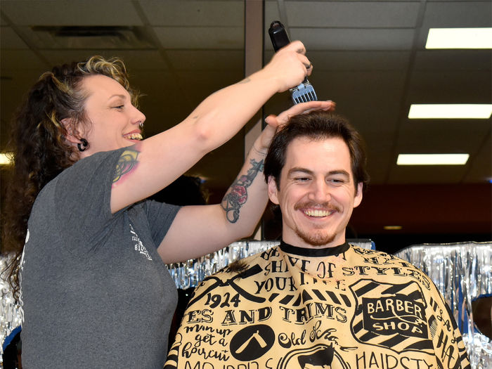 Student Jeff Romano smiles after achieving his donation goal and prepares for his haircut to begin during the 2025 THON hair auction at Penn State DuBois.