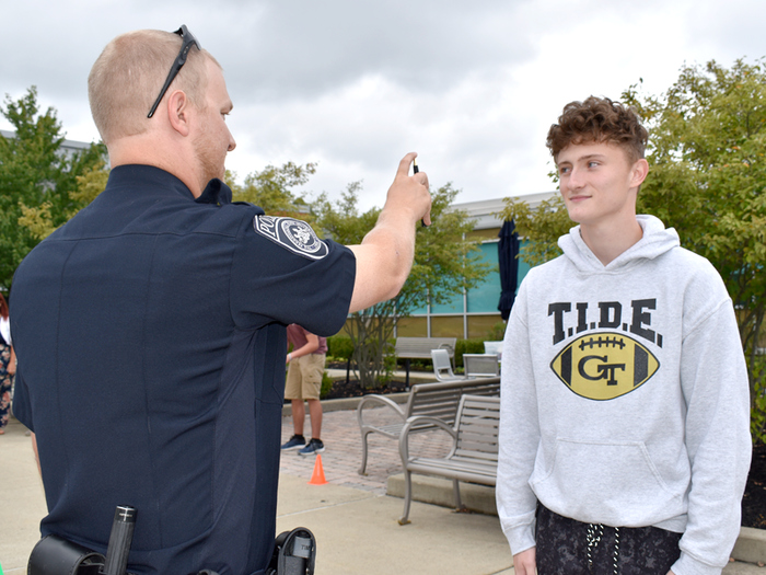 Officer Haag explains the eye test process called horizontal gaze nystagmus with student volunteer, Thad Butler.