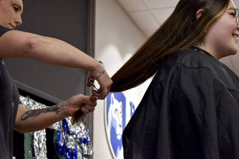 Louise Bennett has her hair cut from behind during the THON hair auction