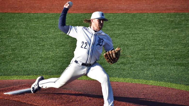 baseball player pitching, arm drawn back mid-throw