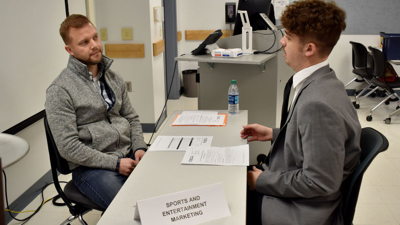 A student gives his role play scenario presentation to a judge during the 2022 Pennsylvania DECA district one conference.
