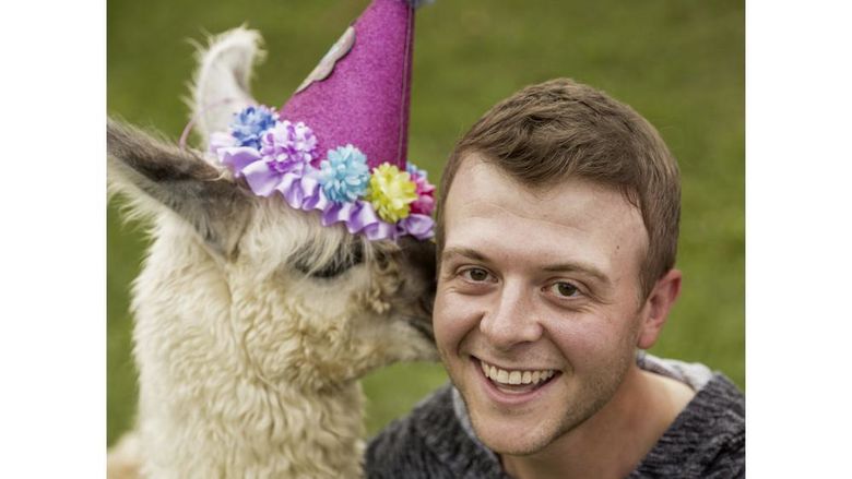 Comedian Derrick Knopsnyder being kissed by a llama