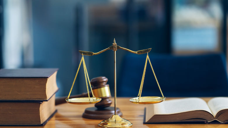 Symbols from the criminal justice system; a scale, a gavel and legal textbooks