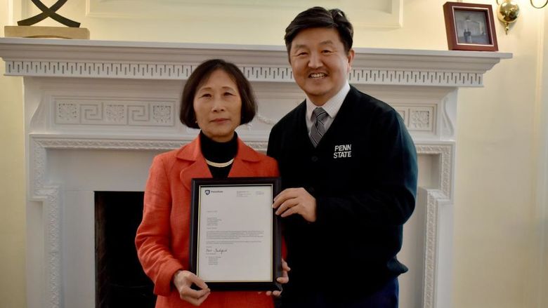 Penn State DuBois chancellor and chief academic officer Jungwoo Ryoo, right, presents Pingjuan Werner with a framed copy of the letter certifying her as a distinguished professor, the highest professorial distinction at the University