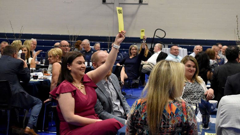 A bidding battle breaks out for one of the items up for auction during the Lion Wine and Cheese live auction at the PAW Center