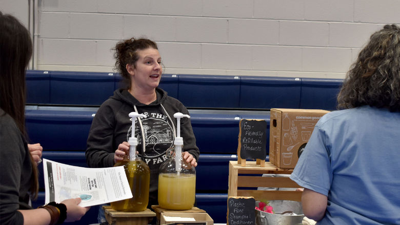 Representatives from Calhoun Farms explaining their sustainability efforts through ecofriendly refillable products to attendees of the Earth Day celebration at Penn State DuBois