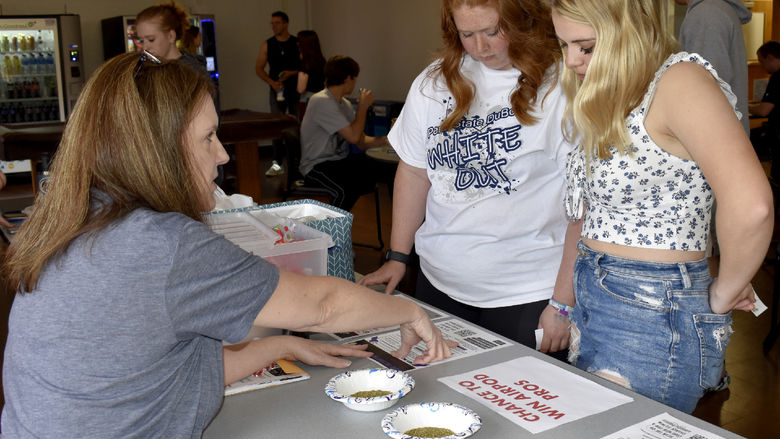 Penn State DuBois students Chelsea Busatto, left, and Makena Baney take part in an interactive learning exercise about fentanyl, with guidance from Jill Betton, health services coordinator and campus nurse, during the Weed It Out event on campus