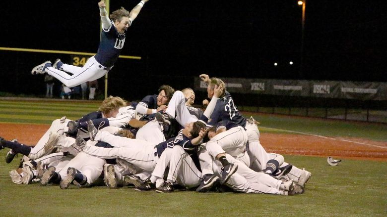 Penn State DuBois players celebrate winning the national championship with a dog pile near the pitcher’s mound at Shower Field