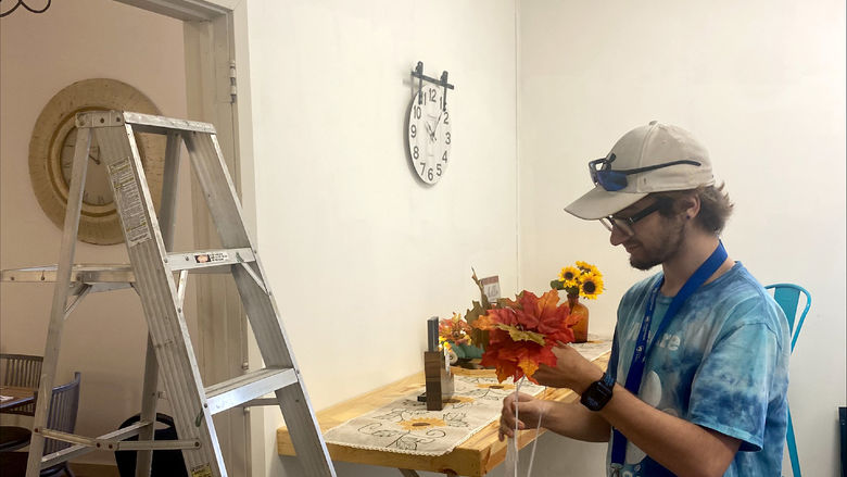 Penn State DuBois student Austin Dinsmore hangs fall decor at the Soul Platter Café during the recent day of service.