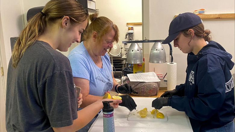 Penn State DuBois students Hannah Allen, left, and Justice Williams, right, work with a Soul Platter Café staff member to help prepare meals during the recent day of service.