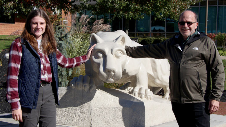 Two people stand on either side of the Lion Shrine