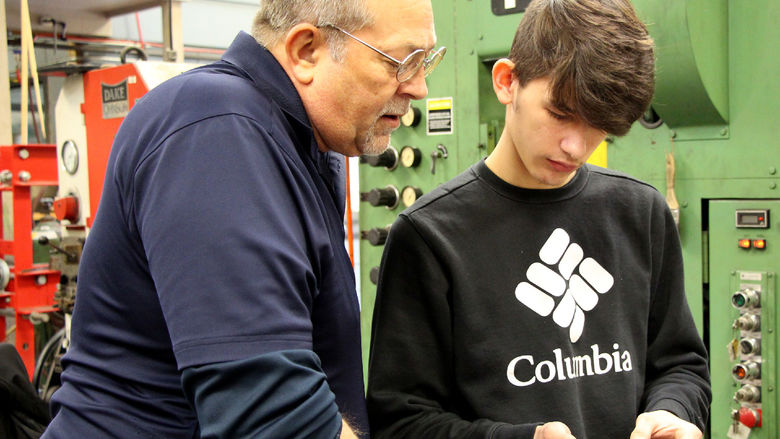 Penn State DuBois die setting instructor George Schneider, left, works with Saint Marys Area High School student Dakota Larkham to measure one of the parts produced during the high school die setter training program.