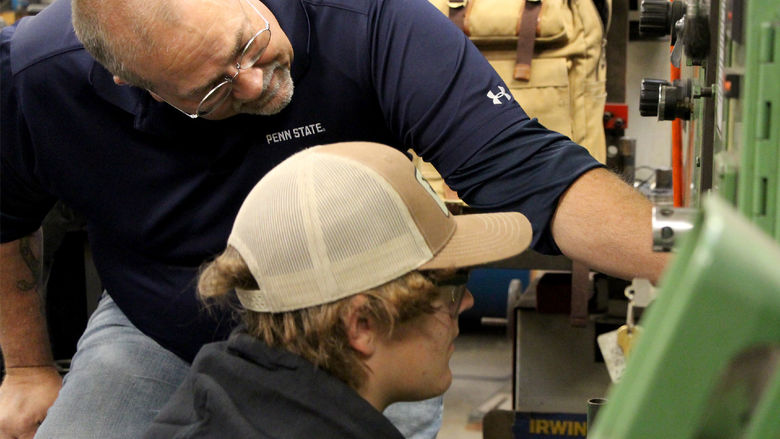 Under the watchful eye of George Schneider, top, Saint Marys Area High School student Justin Herbstritt works through set up procedures for a die set during the high school die setter training program.