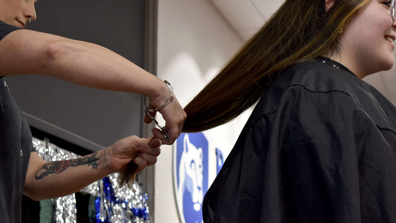 Louise Bennett has her hair cut from behind during the THON hair auction