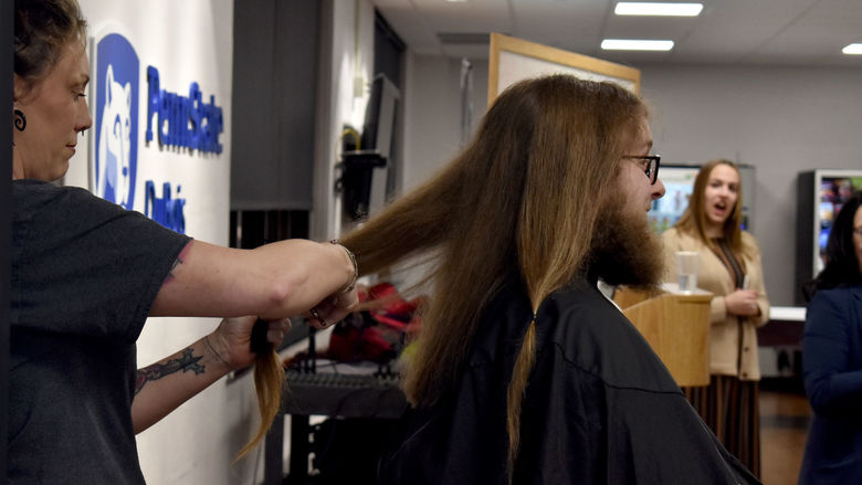Josh Rishel's hair is cut during the THON hair auction after his donation goal was met
