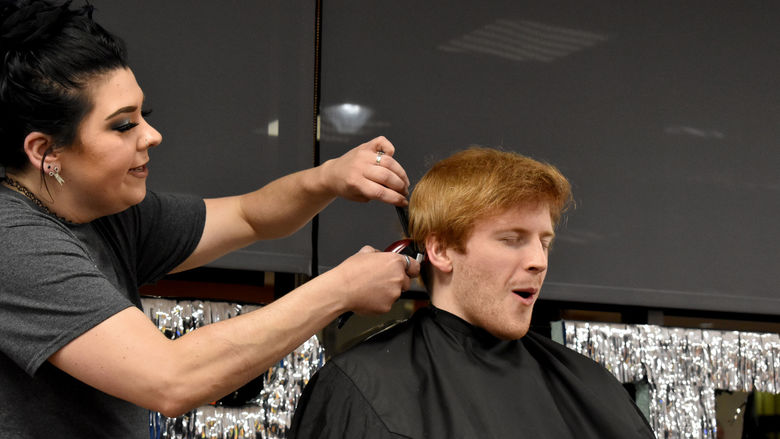 Eamon Jamieson feels the clippers for the first time as his head gets buzzed during the THON hair auction