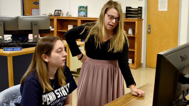 Taylor Charles reviewing information with Brittany Stanton, assistant director of student engagement, as part of her logistics internship at Penn State DuBois