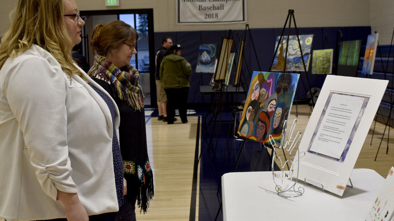 Attendees view some of the artwork submitted at the annual campus and community art show, hosted by the IDREAM Team at Penn State DuBois.