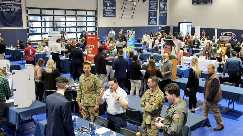A full gym floor at the PAW Center, with the floor being full of employers, students, alumni and community members during the career fair.