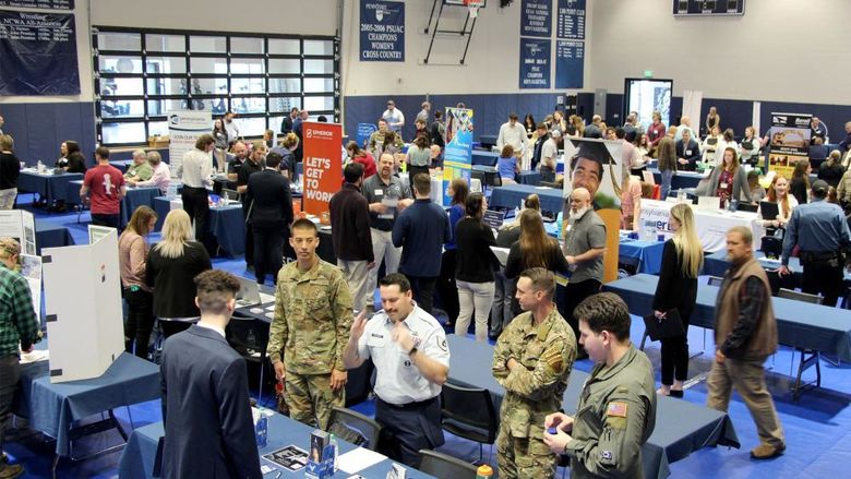 A full gym floor at the PAW Center, with the floor being full of employers, students, alumni and community members during the career fair.