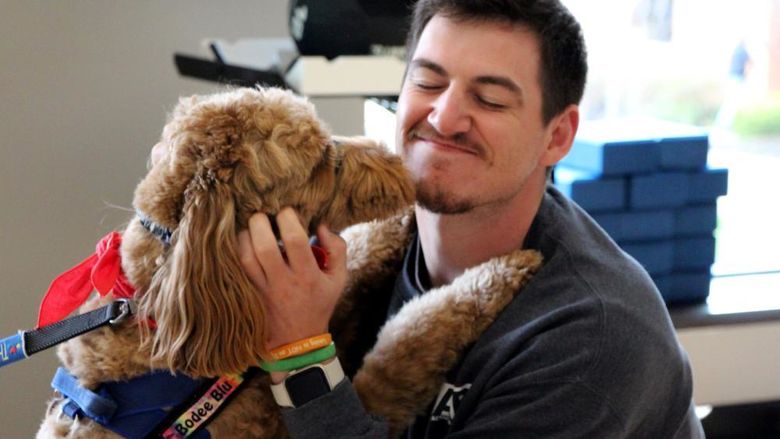 Penn State DuBois third-year student Jeff Romano enjoys the comfort a therapy dog gives him during one of the events of De-Stress Fest at Penn State DuBois.