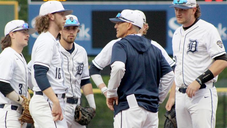 Penn State DuBois head coach Tom Calliari, center, talks with his players during a mound visit in a game during the USCAA Small College World Series.