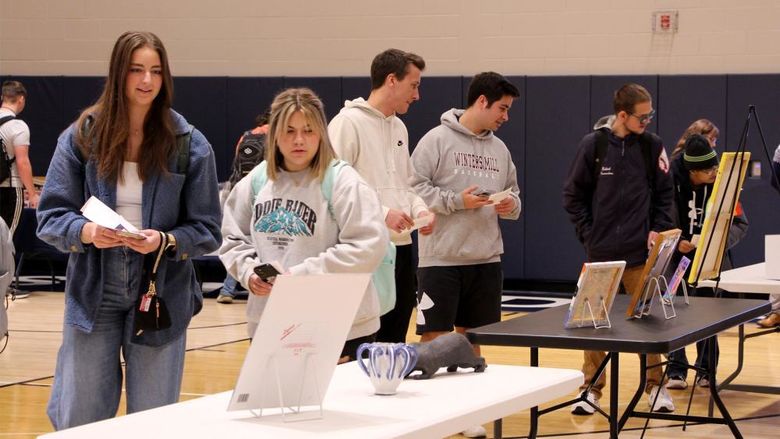 Attendees view some of the artwork submitted at the annual campus and community art show, hosted by the IDREAM Team at Penn State DuBois.