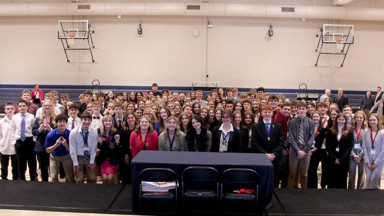 All students who participated in the 2024 Pennsylvania DECA District 1 conference gather for a group photo on the gym floor at the PAW Center, on the campus of Penn State DuBois.