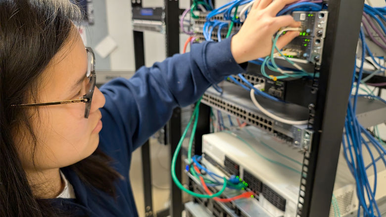Penn State DuBois student Katy Fritz connects one of the enterprise-class virtualization servers to the network system in one of the IST labs at Penn State DuBois.