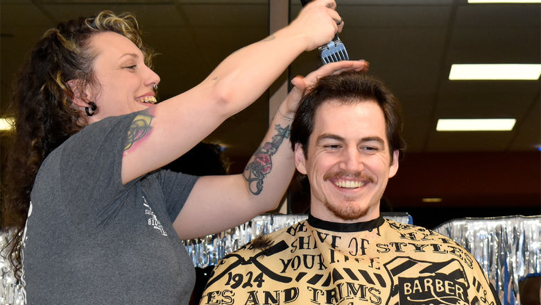 Student Jeff Romano smiles after achieving his donation goal and prepares for his haircut to begin during the 2025 THON hair auction at Penn State DuBois.