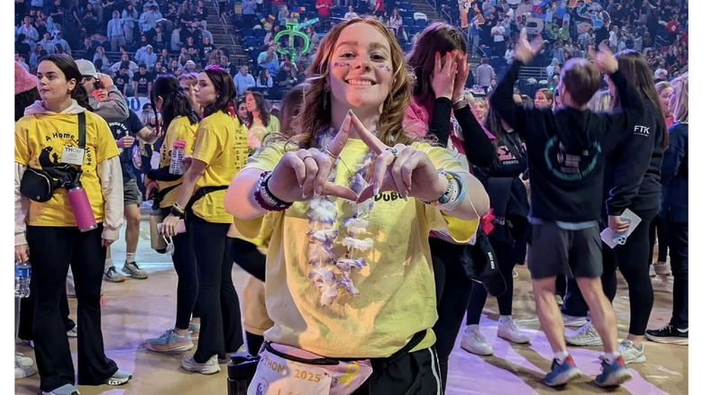 Penn State DuBois student Amber Eberly stands on the dancefloor at the Bryce Jordan Center during THON 2025.